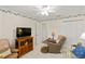 Living room featuring carpeting, ceiling fan, furniture, and natural light from a window at 1526 Blueberry Way, The Villages, FL 32162