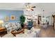 Bright living room featuring an open floor plan, wood floors, and a view into the kitchen and dining area at 1526 Blueberry Way, The Villages, FL 32162