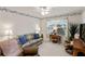 Comfortable living room featuring a cozy sofa, armchair, and large window at 1526 Blueberry Way, The Villages, FL 32162