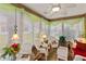 Inviting sunroom with white wicker furniture, brick floors, and large windows at 1526 Blueberry Way, The Villages, FL 32162