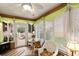 Bright sunroom with brick floors, white wicker furniture, and plenty of natural light at 1526 Blueberry Way, The Villages, FL 32162