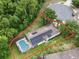 Aerial view showcases the house's layout, screened-in pool, and solar panels within its property lines at 156 Ridgebrook Ct, Davenport, FL 33896