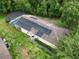 Aerial view of the house with solar panels and a screened-in pool in a lush backyard at 156 Ridgebrook Ct, Davenport, FL 33896