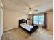 Bedroom with carpet, ceiling fan, window, and a dark frame bed at 156 Ridgebrook Ct, Davenport, FL 33896
