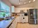 Bright kitchen with white cabinetry, stainless steel appliances, and a sunny window at 156 Ridgebrook Ct, Davenport, FL 33896