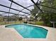 In-ground pool surrounded by a screened enclosure and an outdoor lounge area at 156 Ridgebrook Ct, Davenport, FL 33896