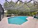 An inviting in-ground pool surrounded by a screened enclosure and mature trees at 156 Ridgebrook Ct, Davenport, FL 33896