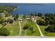 Aerial view showcasing a large property with lake access and well-maintained homes surrounded by trees at 16047 E Shirley Shores Rd, Tavares, FL 32778