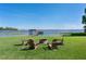 Lawn featuring a cozy fire pit area with chairs overlooking a tranquil lake and dock at 16047 E Shirley Shores Rd, Tavares, FL 32778