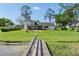 Water view of the house from the lake featuring a backyard firepit with chairs and private dock at 16047 E Shirley Shores Rd, Tavares, FL 32778