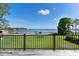 Backyard view from deck with beautiful green grass, trees, and lake at 16047 E Shirley Shores Rd, Tavares, FL 32778