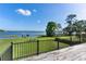 Backyard view from deck with beautiful green grass, trees, and lake at 16047 E Shirley Shores Rd, Tavares, FL 32778