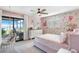 Bedroom with a pink floral wallpaper, ceiling fan and sliding glass doors to the outdoors at 16047 E Shirley Shores Rd, Tavares, FL 32778