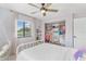 Bedroom with a white bed, ceiling fan, and window at 16047 E Shirley Shores Rd, Tavares, FL 32778