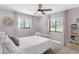 Bedroom with a white bed, ceiling fan, and two windows at 16047 E Shirley Shores Rd, Tavares, FL 32778