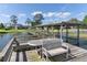 View of the lake and modern house from a dock with benches and seating overlooking tranquil water at 16047 E Shirley Shores Rd, Tavares, FL 32778