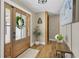 Inviting entryway with wood floors, a decorative wreath on the glass door, and stylish accents at 16047 E Shirley Shores Rd, Tavares, FL 32778