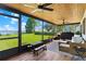 The screened-in porch has a water view, ceiling fans, wood ceiling, wicker furniture and a small picnic table at 16047 E Shirley Shores Rd, Tavares, FL 32778