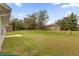 Green backyard with mature trees and plentiful lawn space at 16380 Se 83Rd Ct, Summerfield, FL 34491