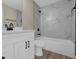 Bathroom featuring white vanity, shower over tub, and marble style tile at 16380 Se 83Rd Ct, Summerfield, FL 34491