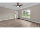 Bright bedroom featuring laminate flooring, neutral paint, a ceiling fan, and a large window at 16380 Se 83Rd Ct, Summerfield, FL 34491