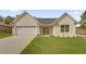Charming single-story home with a two car garage, lush lawn, and neutral colored facade at 16380 Se 83Rd Ct, Summerfield, FL 34491