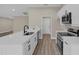 Modern kitchen with white cabinets, quartz countertops, and stainless steel appliances at 16380 Se 83Rd Ct, Summerfield, FL 34491