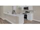 Well-lit kitchen featuring white cabinets, quartz countertops, and stainless steel appliances at 16380 Se 83Rd Ct, Summerfield, FL 34491