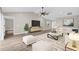 Bright living room featuring high ceilings, a ceiling fan, and sleek laminate floors at 16380 Se 83Rd Ct, Summerfield, FL 34491