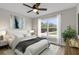 Serene main bedroom showcasing a large window, ceiling fan, and laminate flooring at 16380 Se 83Rd Ct, Summerfield, FL 34491