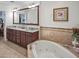 Luxurious bathroom featuring double sinks, granite countertops, and a soaking tub at 1705 S Atlantic Ave # 502, New Smyrna Beach, FL 32169