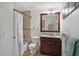 Well-lit bathroom with a shower, vanity, and framed mirror with decorative elements at 1705 S Atlantic Ave # 502, New Smyrna Beach, FL 32169