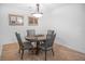 Elegant dining area featuring a modern chandelier, glass table, comfortable seating, and tile flooring at 1705 S Atlantic Ave # 502, New Smyrna Beach, FL 32169