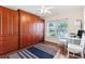 Bedroom with wood flooring, ceiling fan, built in wardrobe, and a window providing natural light at 1716 Bugle Ter, The Villages, FL 32162