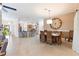 Open-concept dining area with a wicker dining set, oversized clock, and breakfast bar overlooking the kitchen at 1716 Bugle Ter, The Villages, FL 32162