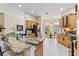 Gourmet kitchen open to breakfast nook featuring stone counters and wooden cabinetry at 1716 Bugle Ter, The Villages, FL 32162