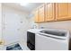 Functional laundry room featuring modern washer, dryer, storage cabinets and utility sink at 1716 Bugle Ter, The Villages, FL 32162