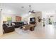 Inviting living room with vaulted ceiling, dark leather sectional, art, and view towards entryway and bar at 1716 Bugle Ter, The Villages, FL 32162