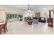 Bright living room featuring a dark leather sectional, neutral seating, and sunroom with views of backyard at 1716 Bugle Ter, The Villages, FL 32162