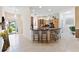 Open concept kitchen and dining area with tiled flooring and a breakfast bar at 1716 Bugle Ter, The Villages, FL 32162