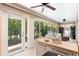 Relaxing sunroom with a refreshment center, ceiling fans, and a view of the lush backyard at 1716 Bugle Ter, The Villages, FL 32162