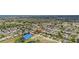 Community aerial view featuring homes, manicured lawns, mature trees, a pond, and tennis courts at 17806 Se 97Th Ct, Summerfield, FL 34491
