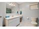 Well-lit bathroom featuring a clean countertop with white cabinets and tiled floors at 17806 Se 97Th Ct, Summerfield, FL 34491