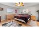 Bright bedroom with wood floors, a ceiling fan, and a large window at 17806 Se 97Th Ct, Summerfield, FL 34491