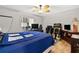 Bright bedroom features blue bedding, wood flooring and a vintage guitar setup at 17806 Se 97Th Ct, Summerfield, FL 34491