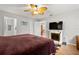 Bedroom featuring wood floors, a ceiling fan, a fireplace, and an ensuite bathroom at 17806 Se 97Th Ct, Summerfield, FL 34491