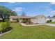 Inviting single-story home featuring red shutters, a well-kept lawn and a two-car garage at 17806 Se 97Th Ct, Summerfield, FL 34491
