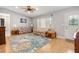 Cozy living room with hardwood floors, ceiling fan, front door, and picture window at 17806 Se 97Th Ct, Summerfield, FL 34491