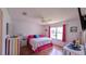 Bedroom with a colorful decor, including a vibrant bedspread, striking wooden floors, and natural light at 17930 Se 83Rd Melody Ave, The Villages, FL 32162