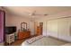 Bright bedroom with wood floors, ceiling fan, dresser, and a closet with sliding doors at 17930 Se 83Rd Melody Ave, The Villages, FL 32162